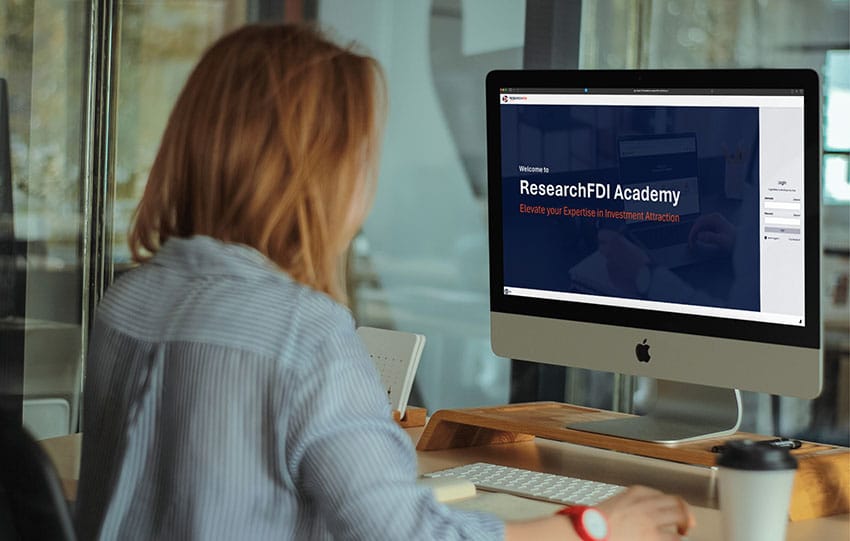 Woman looking at computer with ResearchFDI Academy screen